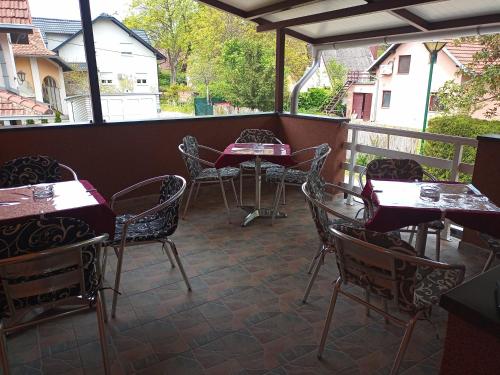 a patio with tables and chairs on a balcony at Sobe Viktorija in Veliko Gradište