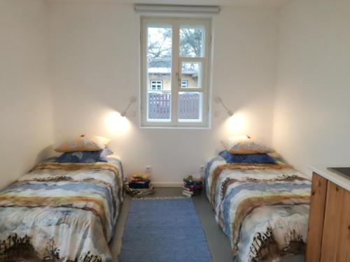 two beds in a room with a window at Matrix Garden Apartments in Tallinn