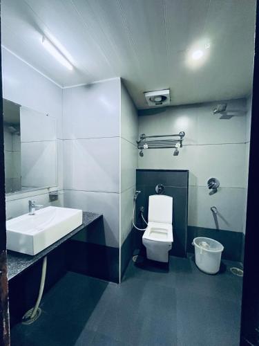 a bathroom with a sink and a toilet at Hotel Chetan International in Bengaluru