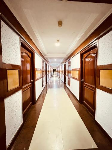 a corridor of a building with a long white aisle at Hotel Chetan International in Bengaluru