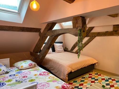 sypialnia z 2 łóżkami pojedynczymi na poddaszu w obiekcie Maison Authentique « Bleue Nuits » w mieście Nuits-Saint-Georges