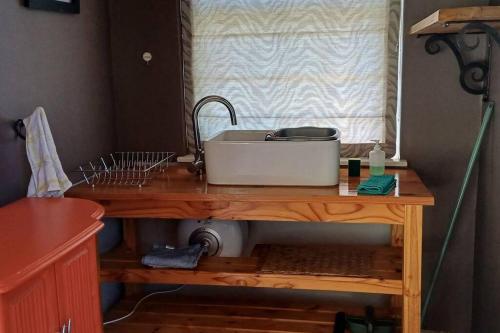 a kitchen counter with a sink on a wooden table at River Studio in Barrydale