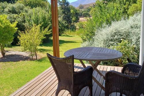 a table and two chairs on a deck with a table at River Studio in Barrydale