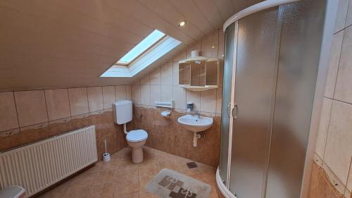 a bathroom with a toilet and a sink and a shower at Family Puškarić in Slunj