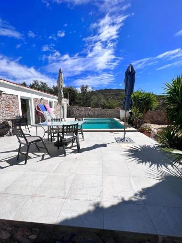 a patio with a table and chairs and a pool at Typical quiet Algarve cottage in Faro