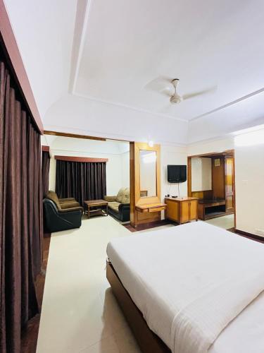 a bedroom with a bed and a living room at Hotel Chetan International in Bengaluru