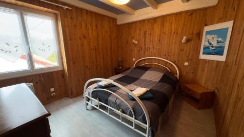 um quarto com uma cama num quarto com paredes de madeira em Location appartement dans Maison Basque em Urcuit