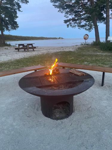 uma fogueira na praia com uma mesa de piquenique em Gotland,Bungeviken em Fårösund