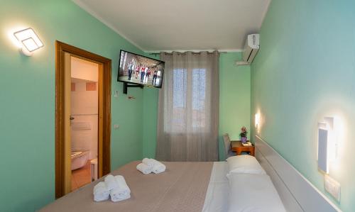 1 dormitorio con 2 camas y TV en la pared en Hotel Villa Benvenuti en Viareggio