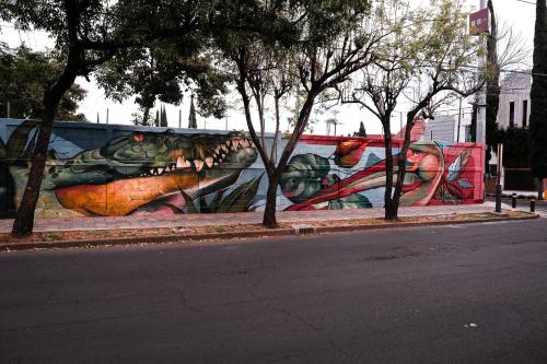 a mural of a lizard on a wall on a street at Urban Style Retreat, Rooftop Views, CDMX 4 in Mexico City