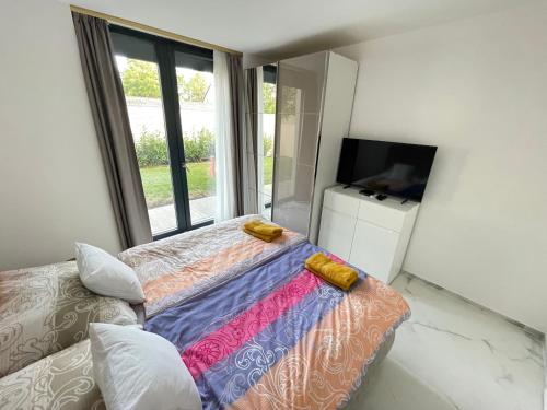 Zimmer mit einem Bett, einem Sofa und einem Fenster in der Unterkunft Luxury Apartments in Balatonalmádi, Almádi Lux Apartman III - Pure Gold in Balatonalmádi