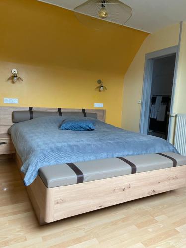 a bedroom with a bed with a blue comforter at La Pénate in Pluduno