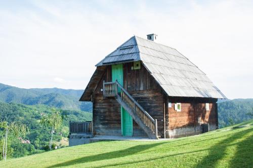 a barn on top of a grassy hill at Mecavnik Resort in Mokra Gora