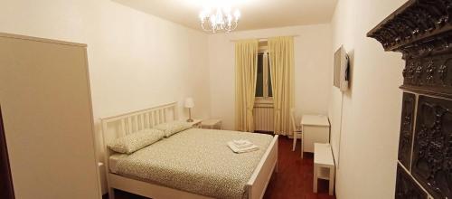 ein kleines Schlafzimmer mit einem Bett und einem Kronleuchter in der Unterkunft Casa Vacanza Città Vecchia in Triest