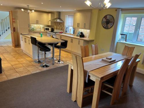 a kitchen and dining room with a table and chairs at Bumblebee Cottage in Skipsea
