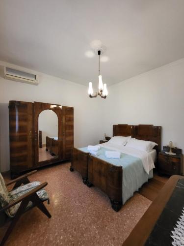 - une chambre avec un lit, un miroir et une chaise dans l'établissement The House of Citrus - amazing country house near Viareggio and Lucca, à Stiava