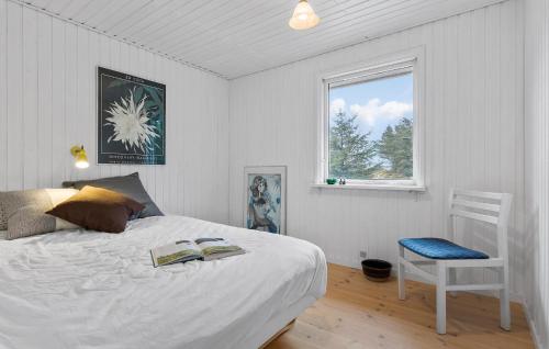 a bedroom with a bed and a chair and a window at Pet Friendly Home In Brovst With Kitchen in Brovst