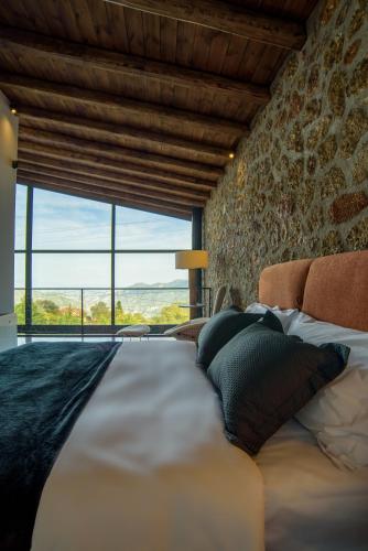 a large bed in a room with a large window at Heartbeat Mountain Escapes in Kato Trikala Korinthias