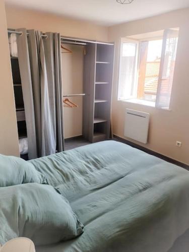 1 dormitorio con 1 cama grande, ventana y armario en Fleurs de Lys en Saint-Germain-Lespinasse