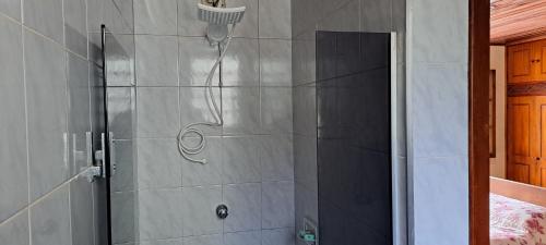 a shower with a shower head in a bathroom at Suíte Com Estacionamento Perto do Centro in Campos do Jordão