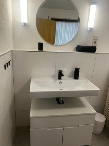 バッハラッハにあるFerienwohnung Pfalzblickの白い洗面台と鏡のあるバスルーム