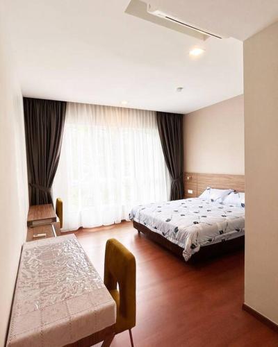 a bedroom with a bed and a table in it at Ipoh Tambun Private Unit Lakeside Residences in Kampong Batu Lapan