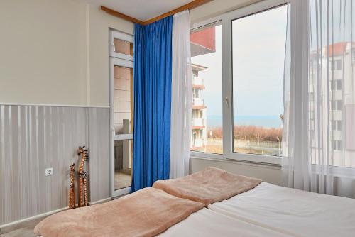 a bedroom with a bed and a large window at Студио Калина in Pomorie