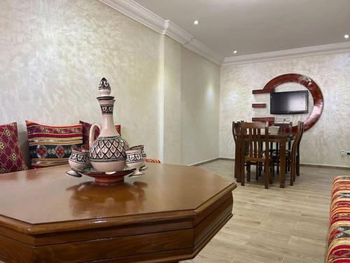 una sala de estar con una mesa con un jarrón. en appart casa voyageurs belvédère, en Casablanca