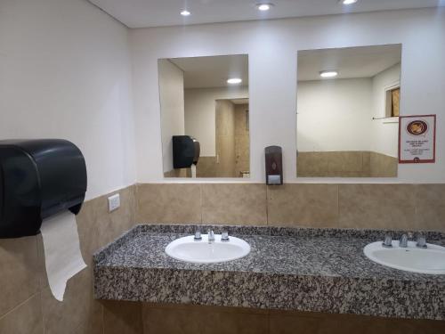baño con 2 lavabos y espejo grande en Rancho Aparte Hostel en El Chaltén
