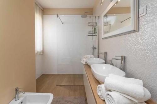 a white bathroom with two sinks and a mirror at Villa Ema in Tar