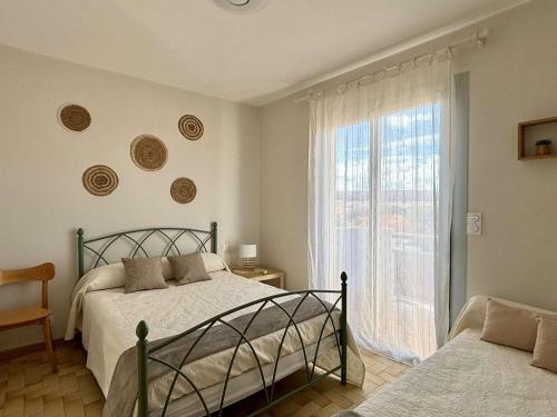 une chambre avec deux lits et une grande fenêtre dans l'établissement Appartement 4 pers, proche plage et commerces, balcon ensoleillé, garage inclus - FR-1-229C-45, à Port-la-Nouvelle