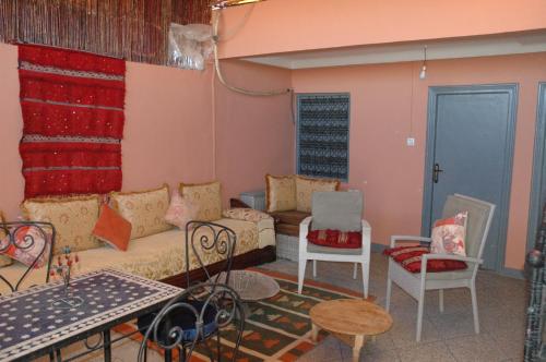 - un salon avec un canapé, une table et des chaises dans l'établissement kech hostel, à Marrakech