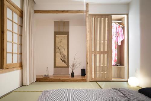 a bedroom with a bed and a mirror and a window at Hajime Homestay Hue in Hue
