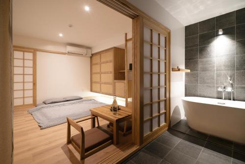 a bathroom with a bed and a bath tub and a table at Hajime Homestay Hue in Hue