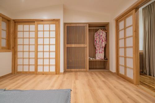 a room with wooden doors and a room with a dress at Hajime Homestay Hue in Hue