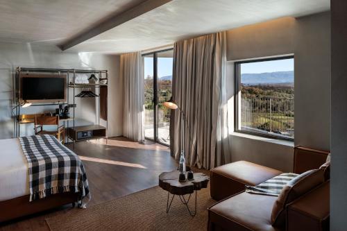 um quarto de hotel com uma cama e uma grande janela em Puro Dão Hotel & Spa em Nelas