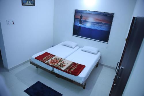 Cama en habitación azul con una foto en la pared en Samyak bunglow, en Dwarka