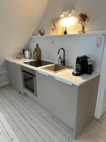 uma cozinha com um lavatório e uma bancada em Cozy City Apartment Daun - Ferienwohnung - EIFEL The Natural Home em Daun