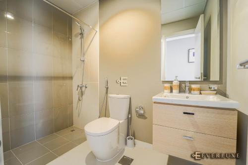 a bathroom with a shower and a toilet and a sink at Everluxe Smart 2 Bedroom Villa In Akoya in Dubai