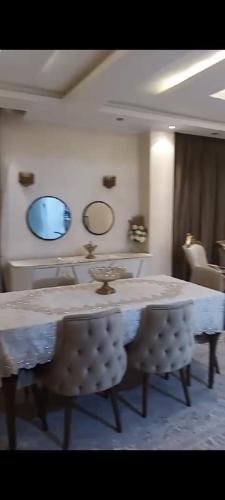 a room with a table and two mirrors on the wall at شقة in Cairo