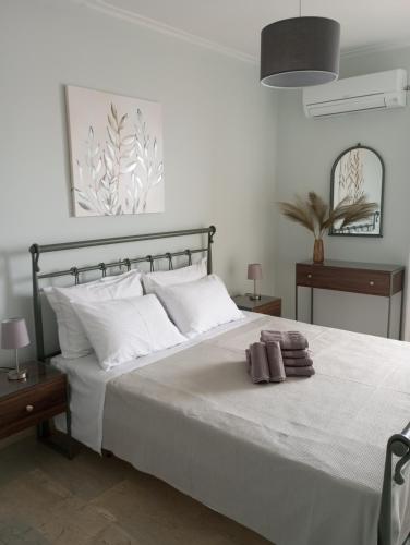 a bedroom with a bed with white sheets and pillows at SKY AND SEA APARTMENT in Xylokastro