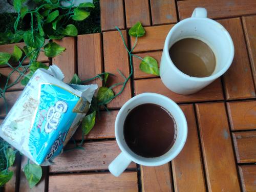 a cup of coffee and a mug of coffee at Studio Healing Sayana Apartment in Tambun-lobangbuaja