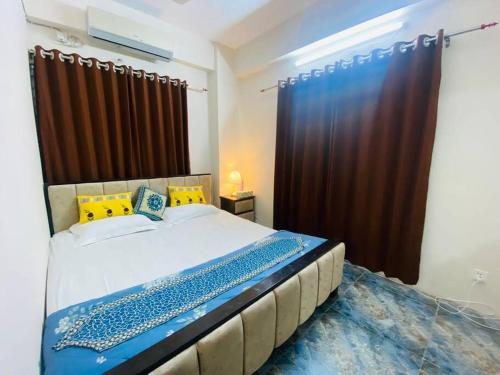 a bedroom with a large bed with a brown curtain at Entire place- Ac 2BHK Apartment Basundhara R/A in Dhaka