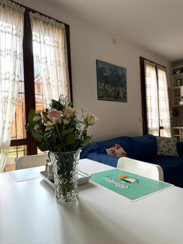 um vaso de flores sentado numa mesa com um livro em A Casa San Pietro - bilocale centro storico - Cyclist-friendly em Castel San Pietro Terme
