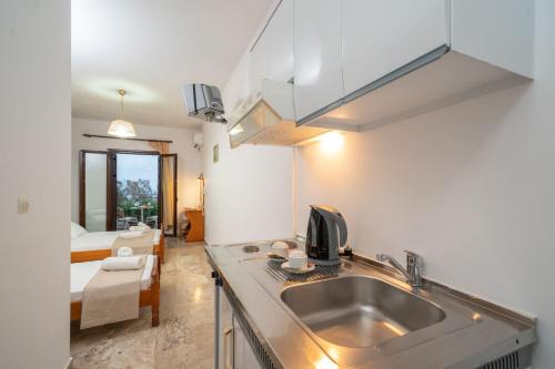 una cocina con fregadero y una cama en una habitación en Karavados Beach Hotel, en Karavádhos