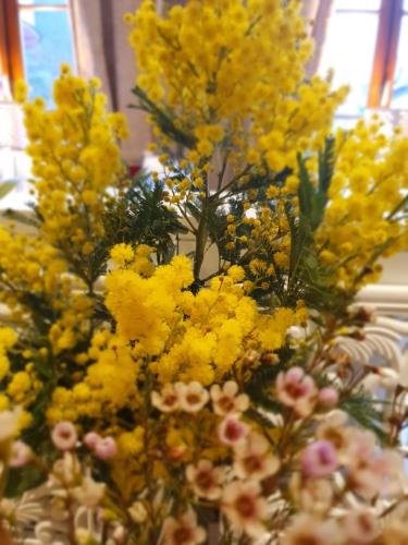 a vase filled with yellow flowers on a table at Hotel de la Gaichel in Eischen