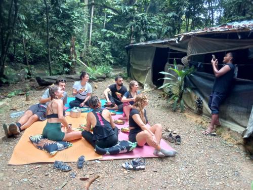 um grupo de pessoas sentadas num cobertor em frente a uma tenda em Jungle treking & Jungle Tour booking with us em Bukit Lawang