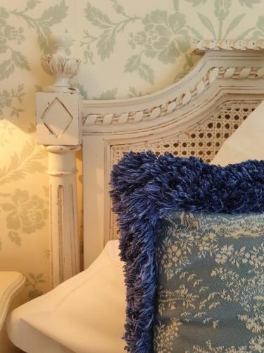 a bedroom with a bed with a blue blanket at Hotel de la Gaichel in Eischen