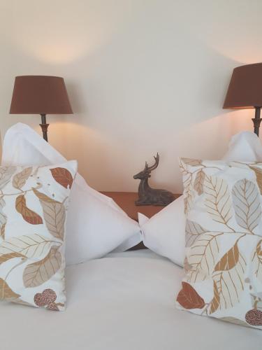a bed with two pillows and a table with two lamps at Hotel de la Gaichel in Eischen