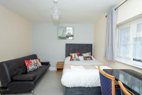 a bedroom with a bed and a couch at Saffron Studios in Orpington